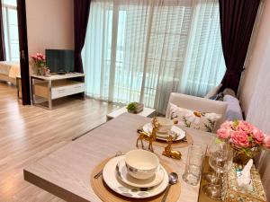 a living room with a table with plates and flowers at My hip Condominium 2 Bedrooms 2 baths comfy room for family in Chiang Mai