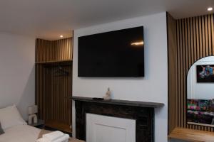 a living room with a flat screen tv on a wall at Ivy House in Boston