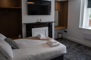 a bedroom with a bed and a fireplace with towels at Ivy House in Boston