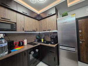 a kitchen with wooden cabinets and a stainless steel refrigerator at DN Kiten in Kiten