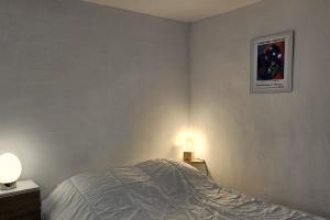 a bedroom with a bed and two lights on the wall at Studio near the city center in Montpellier