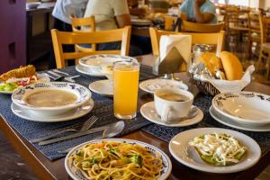 a table with plates of food and cups of orange juice at Hotel Bello Cordoba in Córdoba