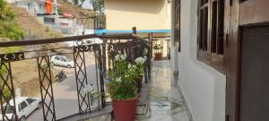 a balcony with a potted plant on a building at Pure Veg Snow Crest Inn in Dharamshala