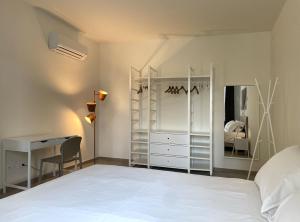 a bedroom with a white bed and a desk at Casa FILA1923 in Biella +72 photos