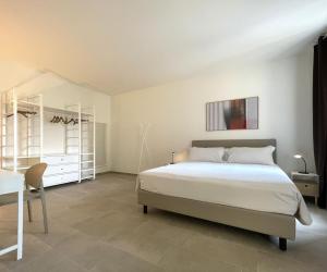 a bedroom with a bed and a table and a desk at Casa FILA1923 in Biella