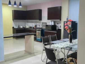 a kitchen with a table with a vase of flowers on it at Quirpinchaca Premier in Sucre