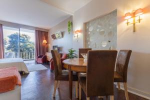a living room with a dining room table and a bedroom at Estoril na praia in Estoril