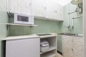 a small kitchen with a microwave and a sink at Estoril na praia in Estoril