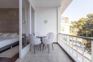 a balcony with a bed and a table and chairs at Estoril na praia in Estoril