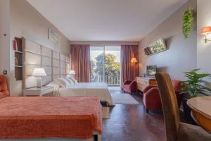 a hotel room with two beds and a balcony at Estoril na praia in Estoril