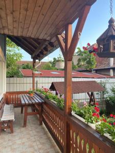 a wooden pergola with a bench on a patio at Bettina Vendégház in Sovata