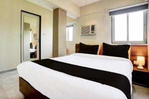 a bedroom with a large white bed with a window at Hotel O Siba Inn in Mumbai