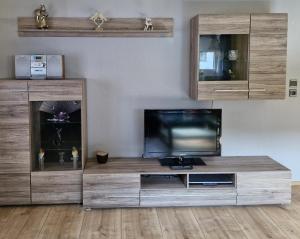a large wooden entertainment center with a flat screen tv at Ferienwohnung Sonnenschein in Weinheim