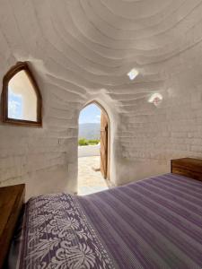 Un dormitorio con una cama en una pared de ladrillo blanco. en Camping01, en Almócita