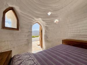 Un dormitorio con una cama en una pared blanca. en Camping01, en Almócita