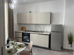 a kitchen with a refrigerator and a table with chairs at A due passi in Balestrate