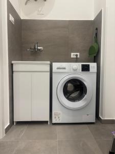 a washing machine in a kitchen with a sink at A due passi in Balestrate