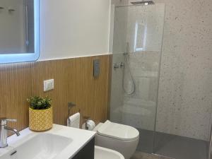 a bathroom with a shower and a toilet and a sink at A due passi in Balestrate +16 photos