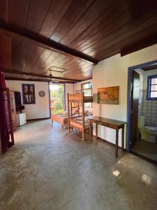 sala de estar con mesa y banco en Vila Pequeá Ilhabela, en Ilhabela
