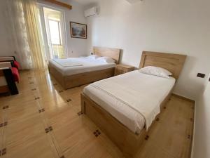 a bedroom with two beds and a window at Vila Përmbi Tepelenë in Tepelenë