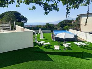 a lawn with umbrellas and chairs on it at Tenuta Coppola in Gragnano
