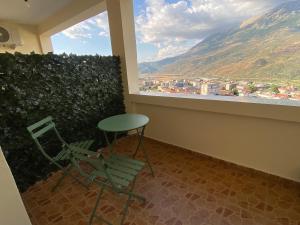 a room with a chair and a table and a window at Vila Përmbi Tepelenë in Tepelenë