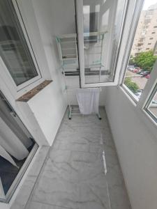 a chair sitting in a room with two windows at Dorobanți Elite Living in Văleni