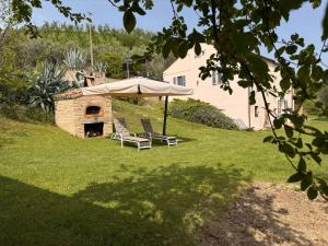 two chairs and an umbrella in a yard at Agriturismo Angeli Sognanti in Cossignano