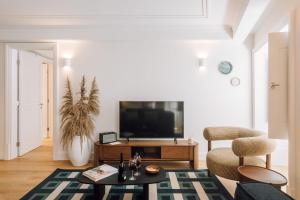 a living room with a tv and a couch at Ando Living - Abrantes 50 House in Lisbon