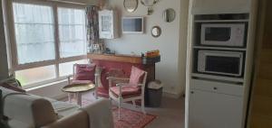 ein Wohnzimmer mit Sofa und eine Küche in der Unterkunft LA BIGOTTIERE DU PORT in Saint-Georges-sur-Cher