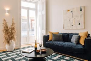 a living room with a blue couch and a table at Ando Living - Abrantes 50 House in Lisbon +265 photos