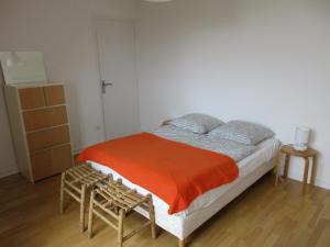 een slaapkamer met een bed met een oranje deken bij Gwenhadu in Paimpol