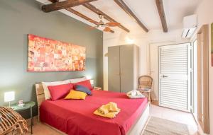 a bedroom with a red bed and a ceiling fan at Lovely Home In Punta Braccetto in Punta Braccetto