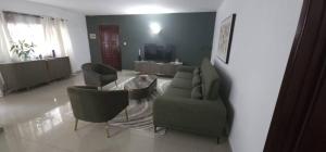 a living room with a couch and chairs and a table at MP's Residence 101 in Pointe-Noire