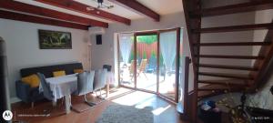 a living room with a table and chairs and a patio at Dom Olena in Bogaczewo