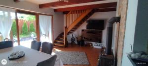 a living room with a dining room table and a staircase at Dom Olena in Bogaczewo