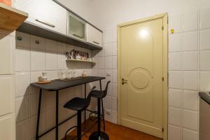 a small kitchen with a stool and a counter and a door at Trevi Garden Suite in Rome +37 photos