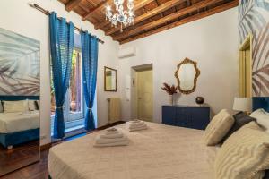 a bedroom with a bed with blue curtains and a mirror at Trevi Garden Suite in Rome