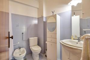 a white bathroom with a toilet and a sink at Palace View Mafra in Mafra