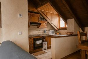 a kitchen with wooden cabinets and a stove top oven at Apartamento Duplex Esterri ideal para familias in Esterri d'Àneu
