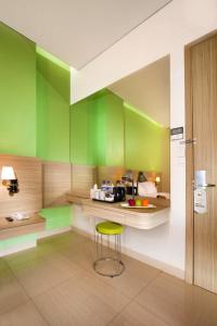 a kitchen with green walls and a stool in it at Whiz Prime Hotel Kelapa Gading in Jakarta