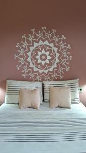 a bedroom with a bed with a mandala on the wall at Pousada Paralelo 14 in Alto Paraíso de Goiás