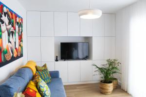 a living room with a blue couch and a tv at Casa da Tasquinha in Ponta Delgada