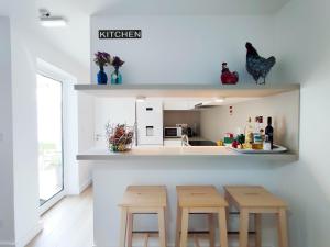 a kitchen with two wooden stools and a counter at Casa da Tasquinha in Ponta Delgada