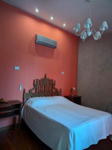 una camera da letto con un letto bianco e una parete rossa di Berta Vidal - Confort, Jacuzzi and Naturaleza a El Durazno