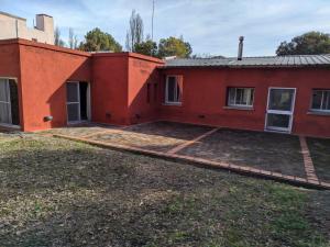 una casa rossa con un grande cortile di fronte di Berta Vidal - Confort, Jacuzzi and Naturaleza a El Durazno