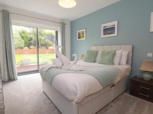 a bedroom with a bed with two swans on it at Môr Glas in Conwy