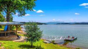 a dock with a boat on the water at Lakefront Mountain Oasis in Dandridge
