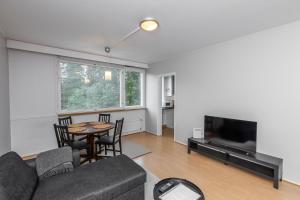 a living room with a couch and a table and a tv at Spacious one-bedroom apartment near downtown in Lahti