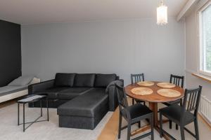 a living room with a black couch and a table at Spacious one-bedroom apartment near downtown in Lahti